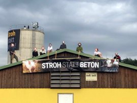 Tierschützer:innen mit Banner am Dach der Tierfabrik