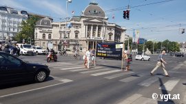 Aktivist_innen demonstrieren mit einem großen Banner an einer Kreuzung in Wien