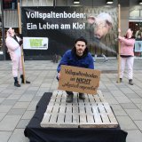 VGT-Aktion Mariahilferstraße Wien: Landwirt auf Vollspaltenboden und Schwein im Bett