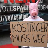 ÖVP-Ministerin Köstinger auf Vollspaltenboden und ein Schwein schaut vom Sessel aus zu